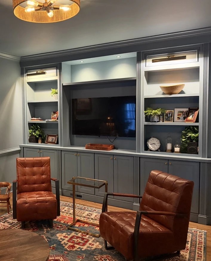 Living room built-in with two leather chairs in front